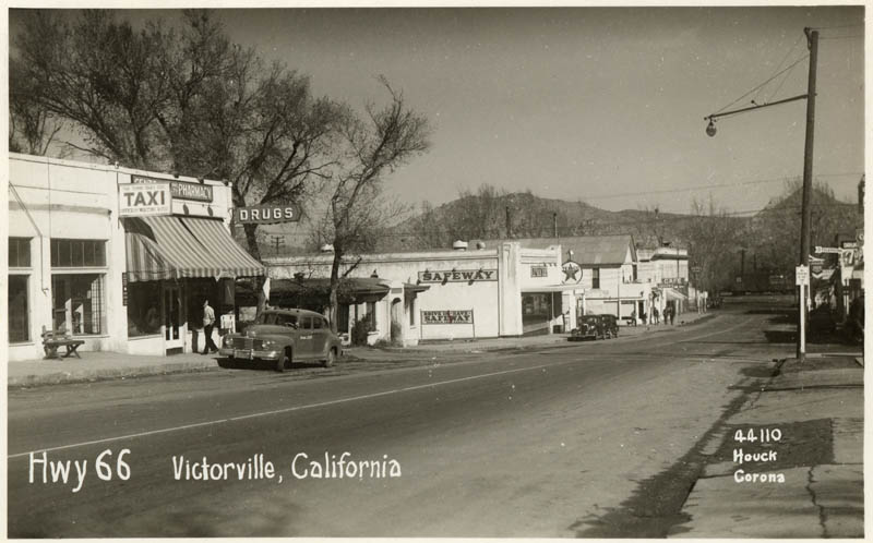 Hwy 66, Victorville. Street with drug store, Taxi sign and Safeway store.