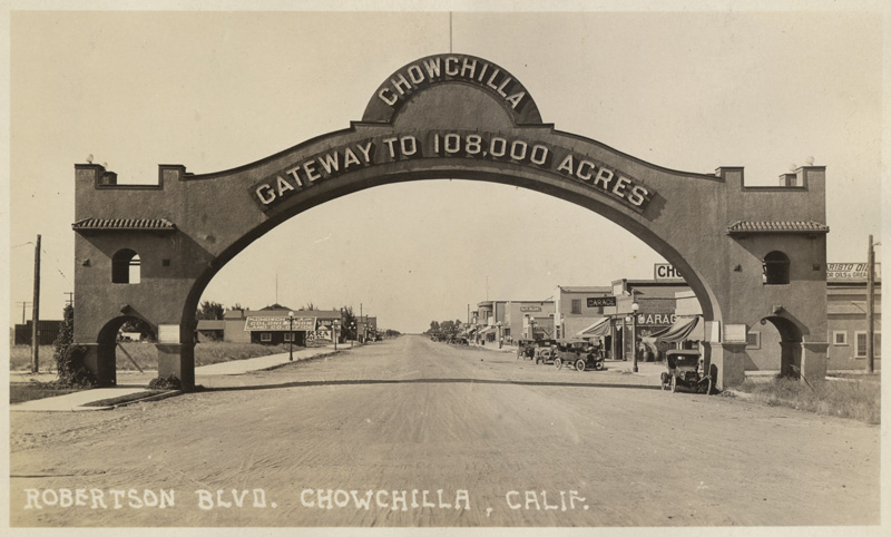 Cement Archway over dirt street says Chowchilla, Gateway to 108,000 acres