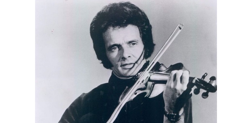 Haggard playing a violin in a publicity portrait for Capitol Records