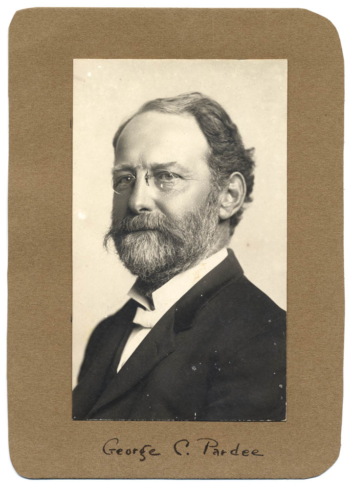 Bust-length portrait of a bearded Pardee wearing glasses.