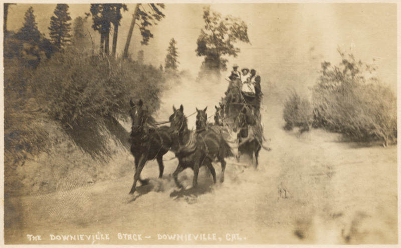 View of stagecoach filled with passengers and led by horse team on road in Downieville.